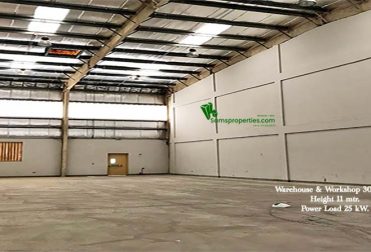 An industrial warehouse approved for workshops and storage. The Width is 23.20 meters, length is 13 meters, and the height is 11 meters. At the back, there is a ventilation window and a door to the backyard. The roofing is fitted with small transparent sheets to let the sunlight come inside. The front area is a tarred path for heavy vehicles for loading and unloading.