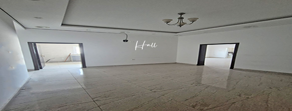 A wide-angle view of a large, empty office hall with two doorways leading to other rooms. A 2 rooms office 100 m2 in the lowest rent of BHD 200 per month at Hidd, Bahrain.
